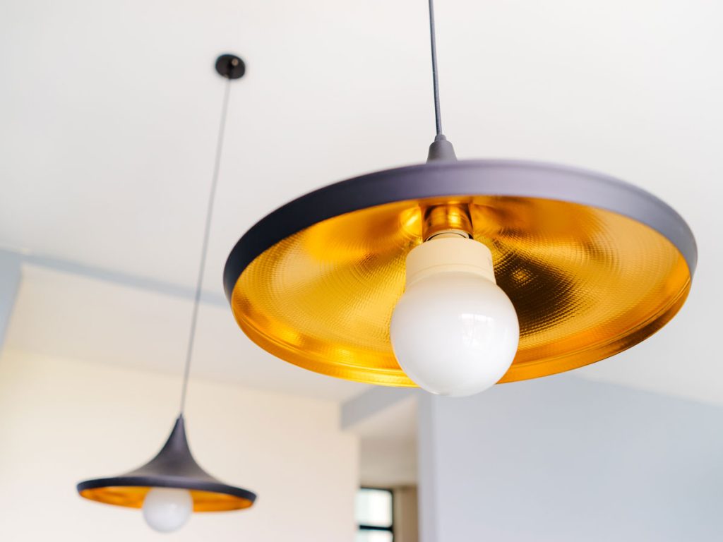 Two black and gold light fixtures with LED bulbs.