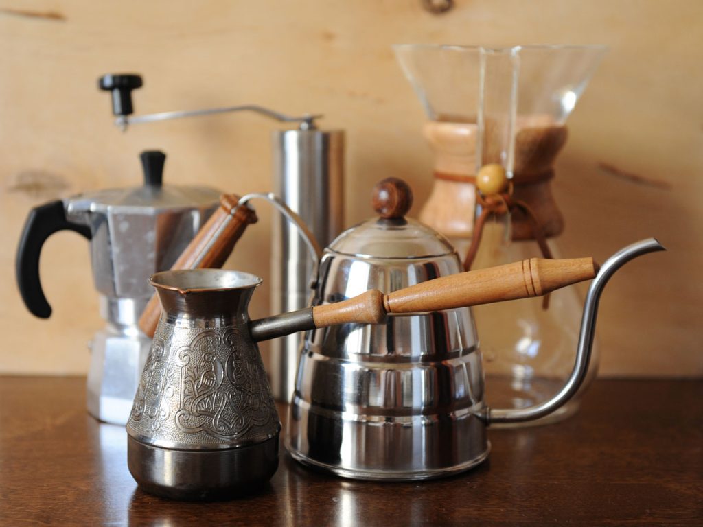 Five of the best plastic free coffee makers on table, including turkish pot, french press, and Chemex.