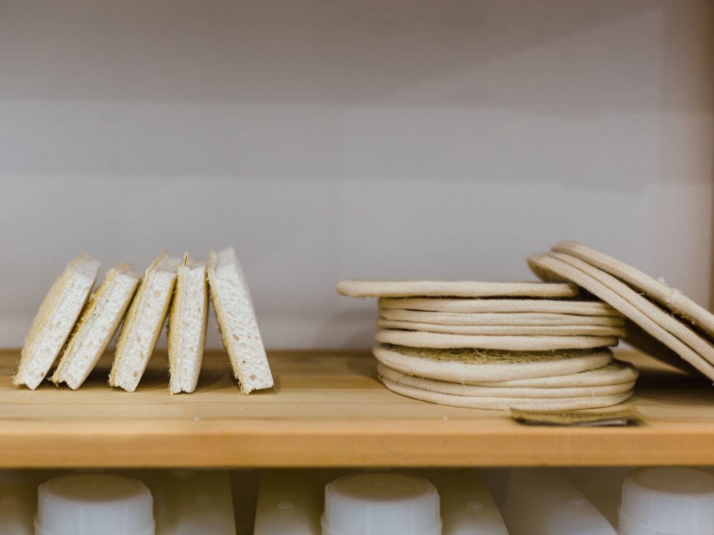 Wooden shelf holding stacks of zero waste dish sponges made of biodegradable materials.