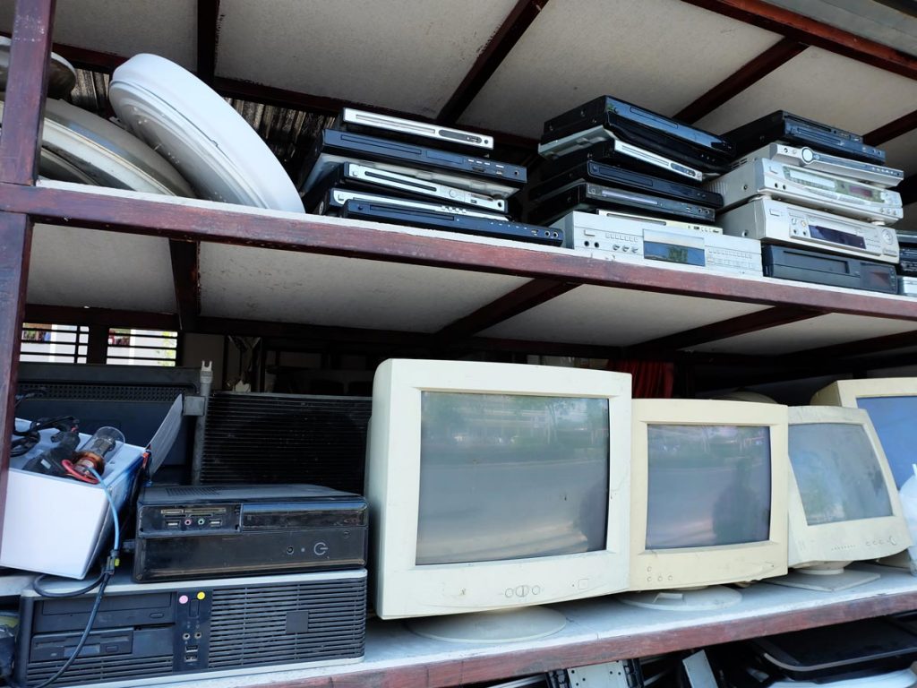 Shelves of electronics and computer monitors at appliance repair store where to dispose of old microwave.