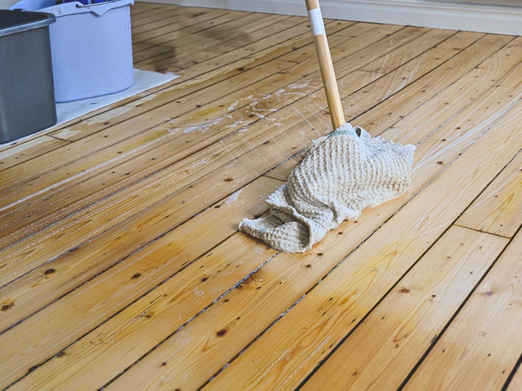 Zero waste mop made of wood and towels cleaning hardwood floors.